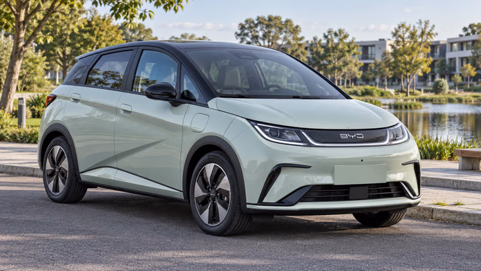 Светло-зелёный BYD Dolphin с тёмной крышей на парковке у парка; синтетическая редакционная иллюстрация.