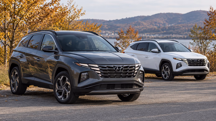 Серый и белый Hyundai Tucson NX4 у осеннего озера — синтетическая редакционная иллюстрация
