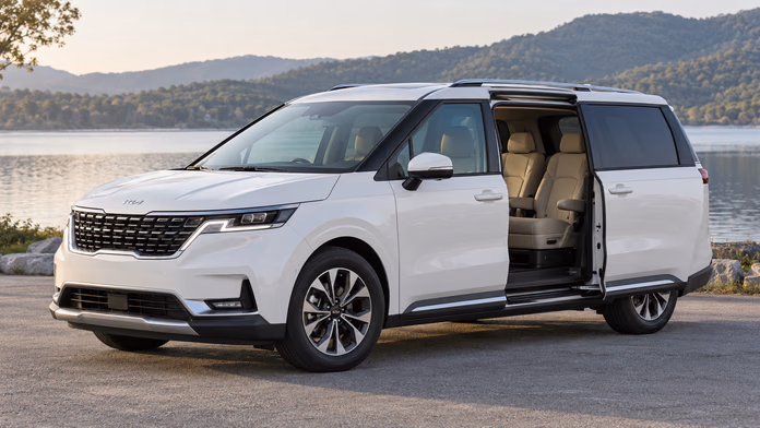 Белый Kia Carnival KA4 с открытой сдвижной дверью у озера — синтетическая редакционная иллюстрация