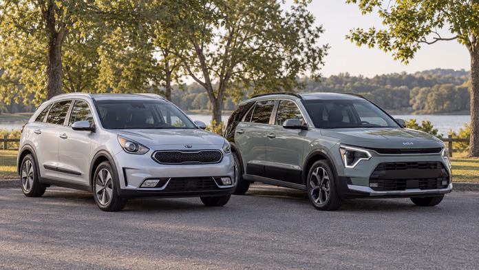 Серебристый Kia Niro DE и светло-зелёный Niro SG2 в парке — синтетическая редакционная иллюстрация