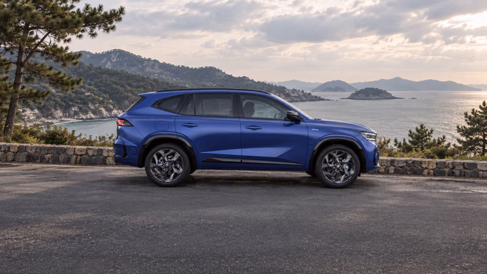 Синий Renault Grand Koleos на прибрежной площадке среди сосен; синтетическая редакционная иллюстрация